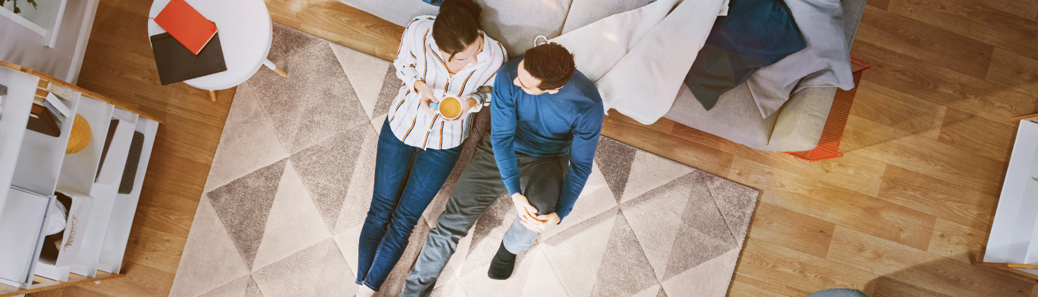 Mann und Frau unterhalten sich gemütlich sitzend auf dem Teppich