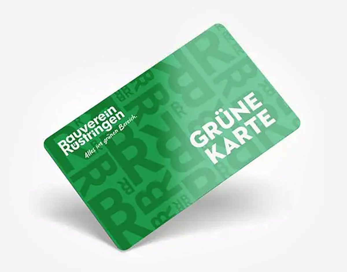 Großvater hält seine Enkelin im Arm, beide lachen und betrachten gemeinsam eine Gießkanne – Sinnbild für Fürsorge und eine Investition in die nächste Generation – Bauverein-Rüstringen Wilhelmshaven.